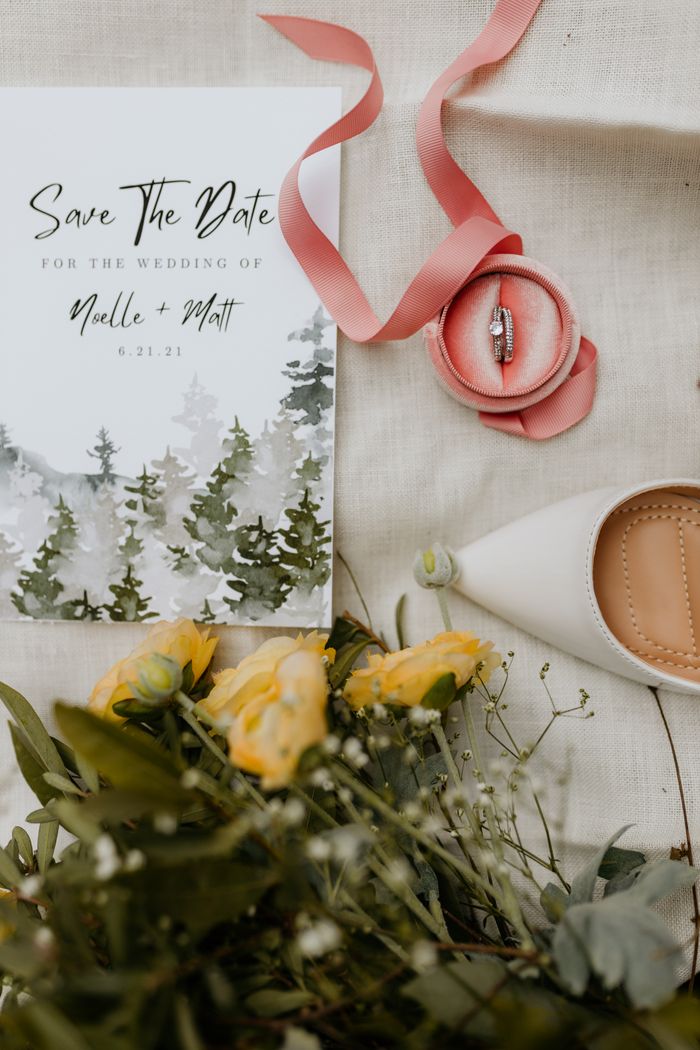 about-bg Stylish wedding setup with invitation, rings, flowers, and shoes.