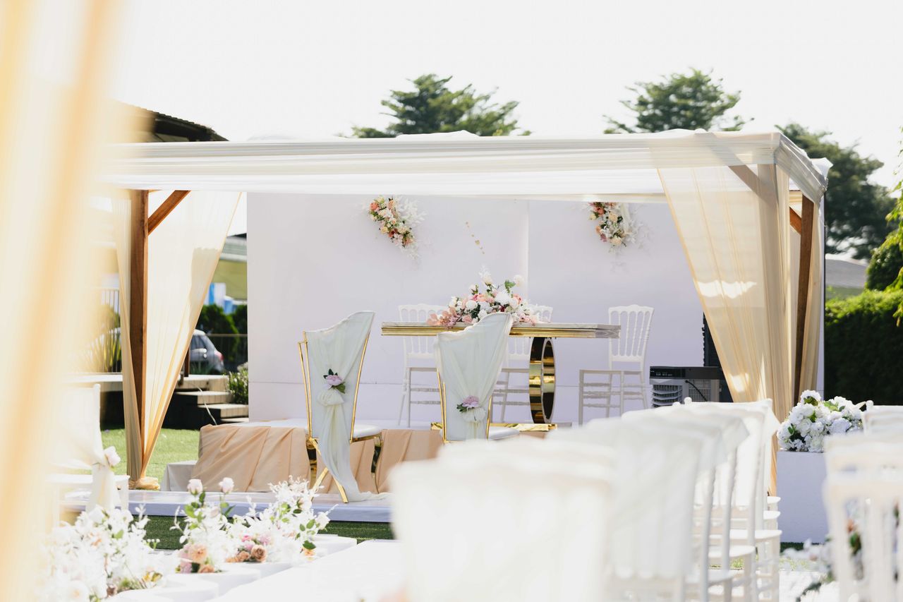 why-choose-us Beautiful outdoor wedding ceremony setting with white and pastel-colored decor and floral arrangements.