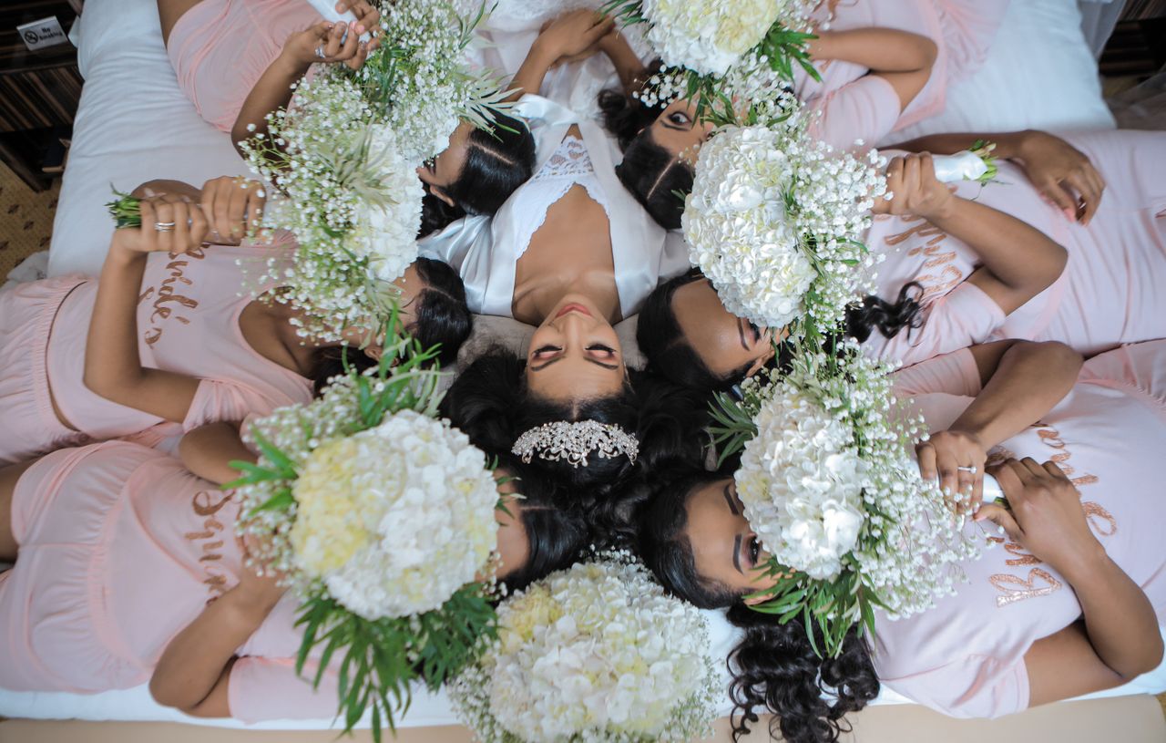 who-we-are Bride and bridesmaids in relaxing pose with flowers on wedding day in Addis Ababa.
